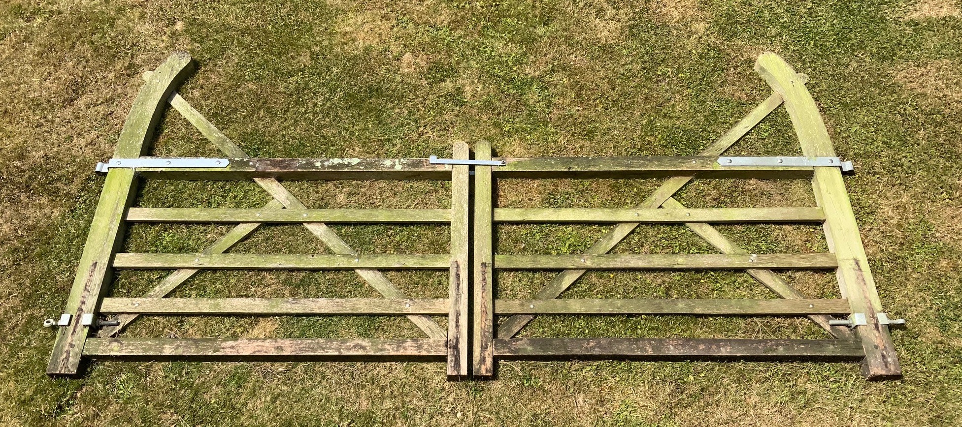 A pair of weathered English oak five bar gates, each gate 167cms (total span touching 334cms). height 120cms. height to top of arm 177cms.